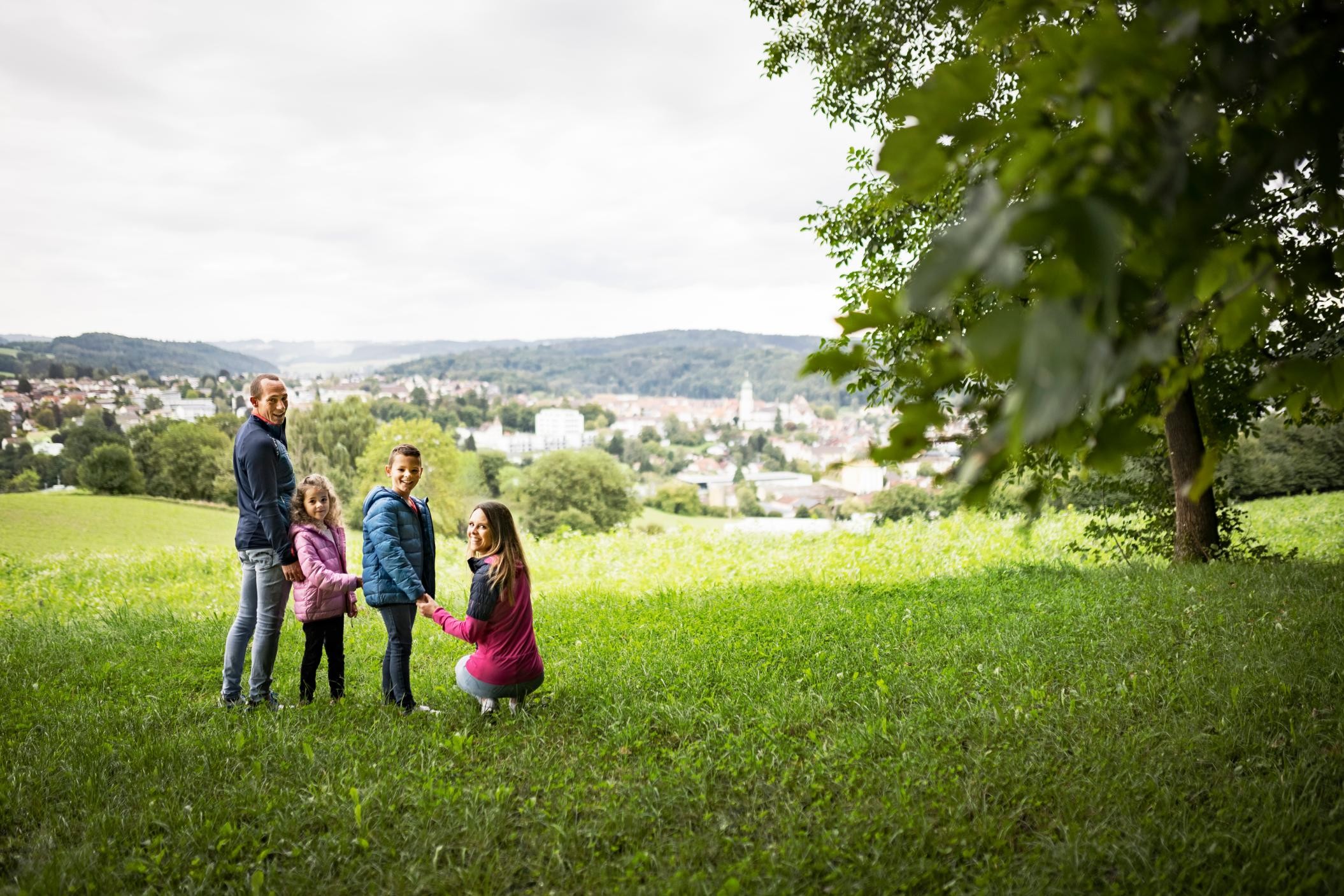 Familie steht an Aussichtspunkt. Im Hintergrund ist Stockach zu sehen.
