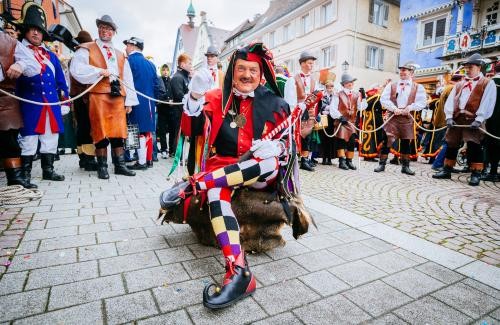 Narr Hans Kuony sitzt verkleidet auf der Straße